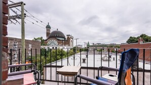 Un balcon donnant sur un grand bâtiment doté d’un dôme et d’une tour horloge.