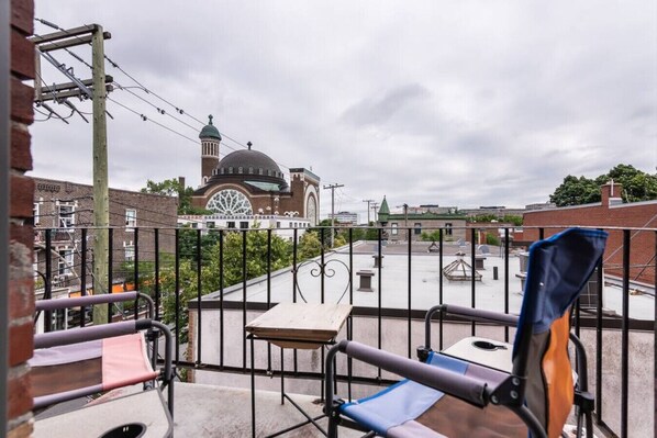 Un balcon donnant sur un grand bâtiment doté d’un dôme et d’une tour horloge.