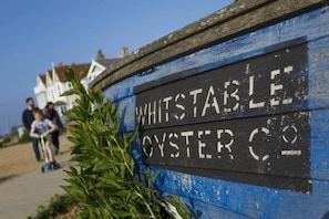 A sign for Whitstable Oyster Co. with a rustic wooden background and white lettering. - Beachfront Retreat With Panoramic Views Of The Bay (Whitstable)