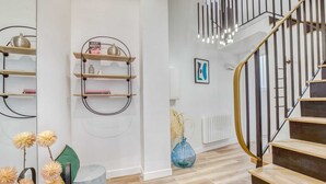 A modern interior with a staircase, wooden shelves, and a radiator.