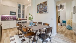 A modern kitchen with white cabinets, a built-in oven, and a purple backsplash.