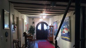 A hallway with a checkered floor, a red carpet, and a wooden cabinet with glass doors. - Historisches Bürgerhaus Coburg (Coburg)