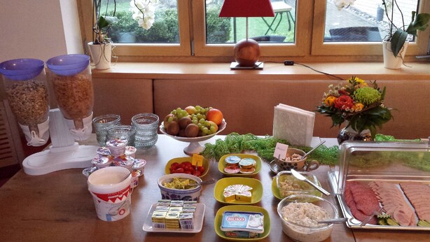 Un bufet amb diferents aliments i condiments, com fruita, formatges i carns.