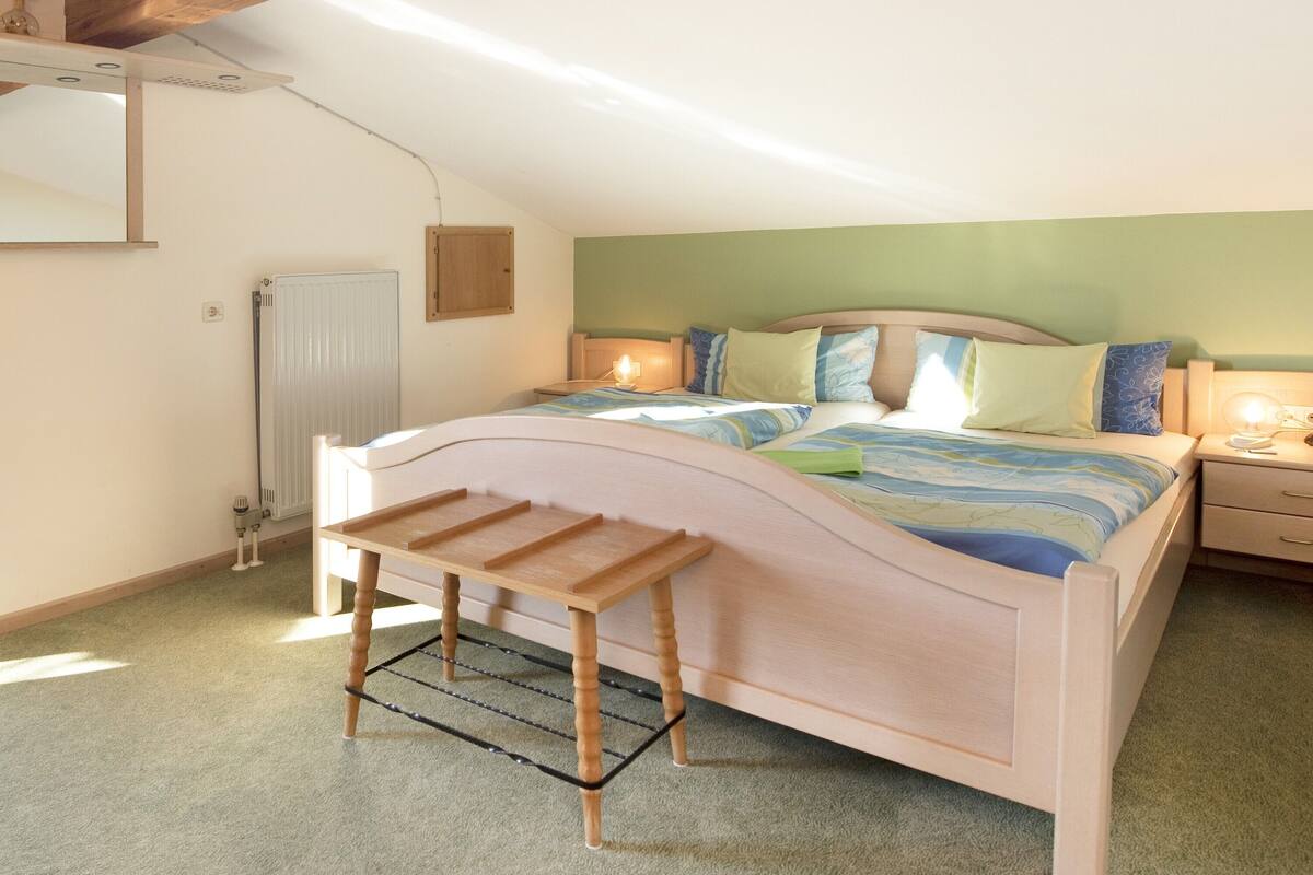 Une chambre à coucher avec un lit, une table de chevet, une lampe et un radiateur.
