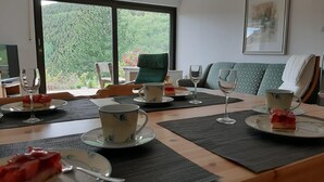 Un comedor con una mesa preparada para cuatro personas, con platos, vasos y cubiertos.