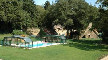Una piscina al aire libre, una piscina climatizada