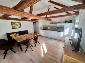 A modern kitchen with white cabinets, a built-in oven, and a coffee maker. - Residenz Nr.6 (Zapfendorf)