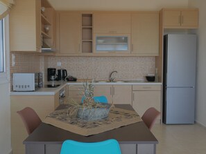 A compact kitchen with a refrigerator, microwave, and coffee maker. - Haravgi villa 3 ,near resort,private pool (Agia Triada)