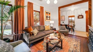 Una sala de estar con un sofá, una mesa de centro y una zona de comedor con sillas y una mesa.