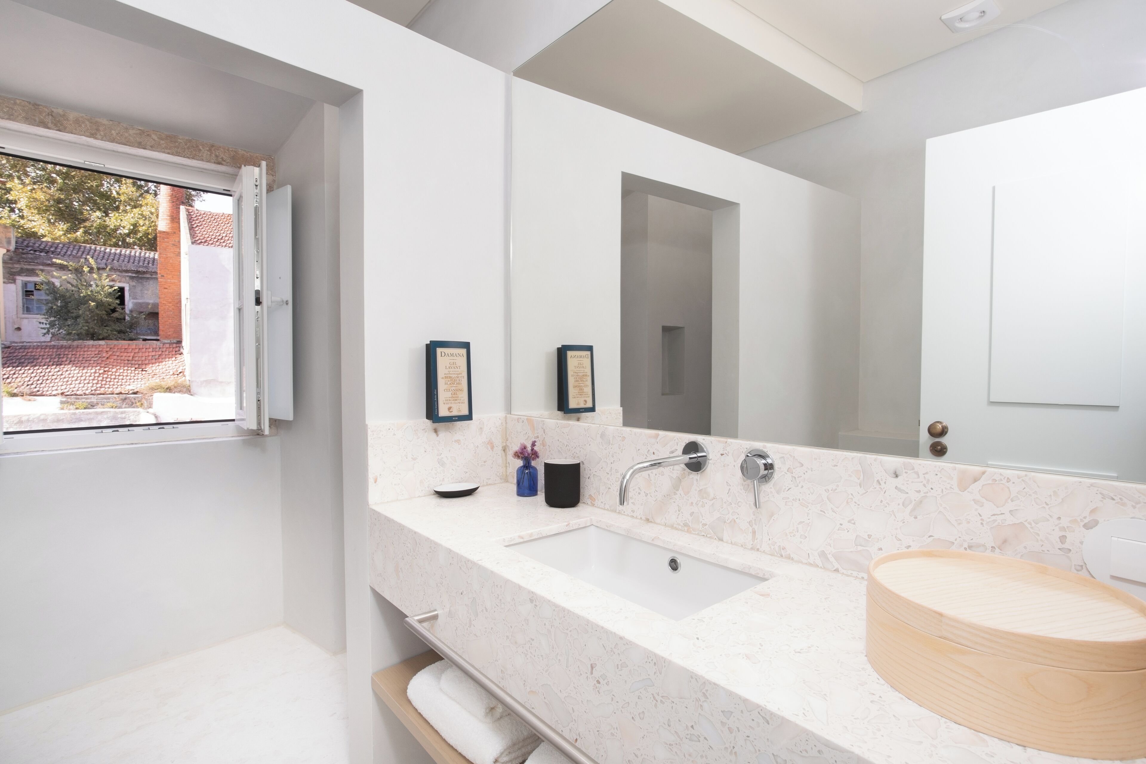 Un bany modern amb un mirall gran, un lavabo i una finestra.