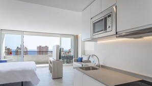 Een moderne keuken met een ingebouwde magnetron, een spoelbak en een kookplaat.