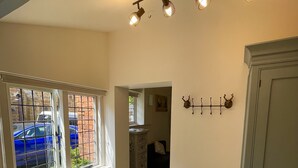 A spacious room with a large window, wooden flooring, a radiator, and a ceiling light fixture. - Hunt House Quarters (Rugby)