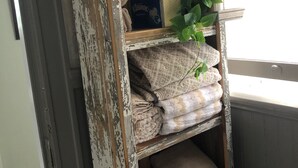 A rustic wooden shelf with towels and a box of Kleenex.
