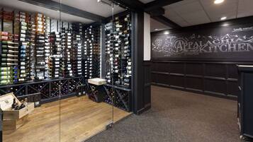 A wine cellar with numerous bottles organized on shelves and racks.