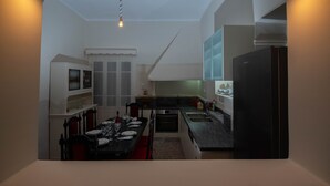 Eine kompakte Küche mit Essbereich, integriertem Backofen und Kühlschrank.