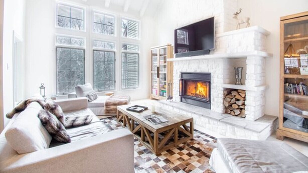 A spacious living room with a fireplace, large windows, and a cozy seating area. - Tremblant Prestige - Panache 632 (Mont-Tremblant)