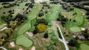 An aerial view of a golf course with multiple greens, sand bunkers, and a clubhouse. - Appartements am Rindhof (Muennerstadt)