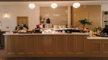 Un mostrador de buffet con diversas opciones de comida y una estación de café.
