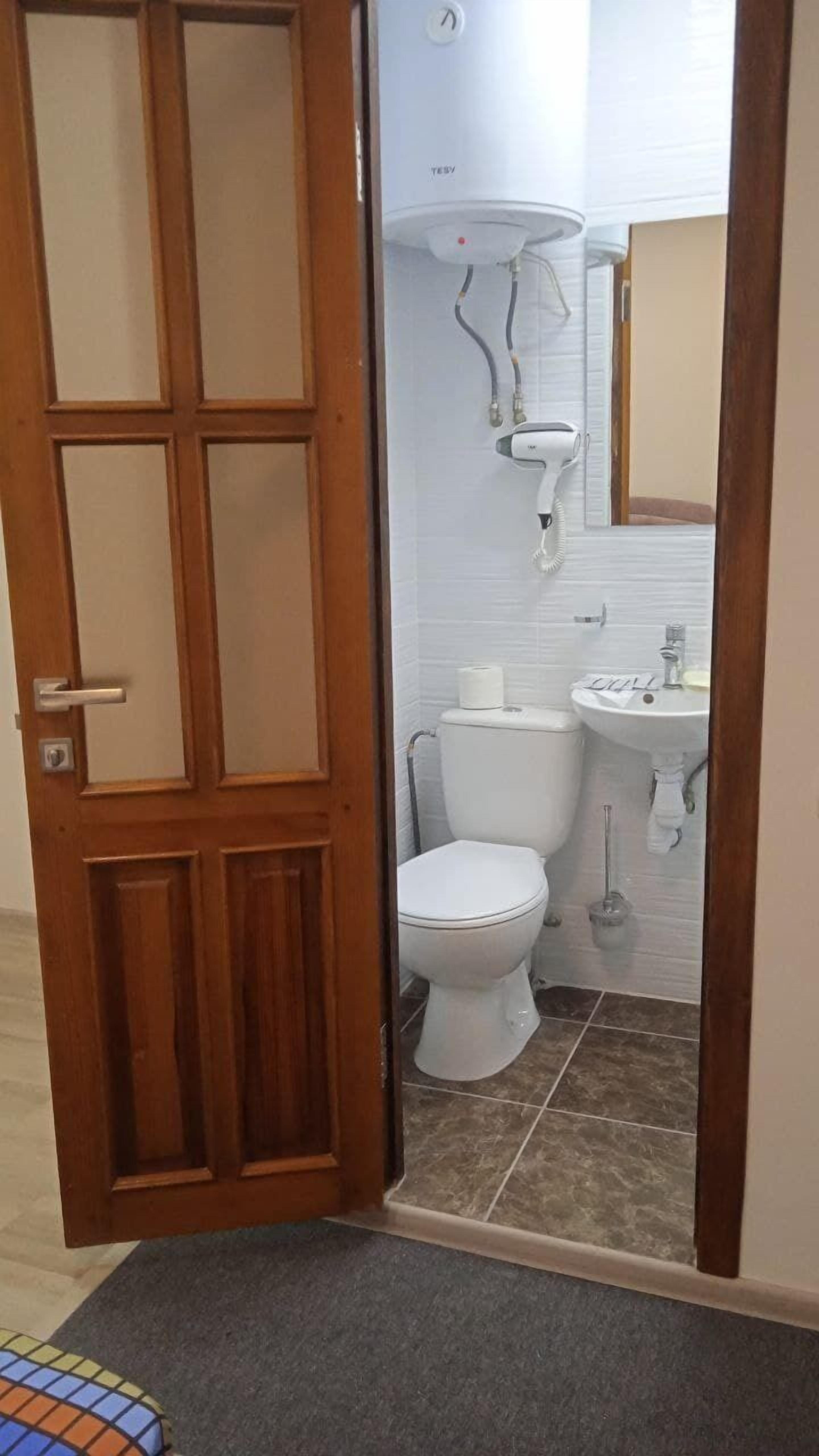 Une salle de bain avec des toilettes, un lavabo et une douche.