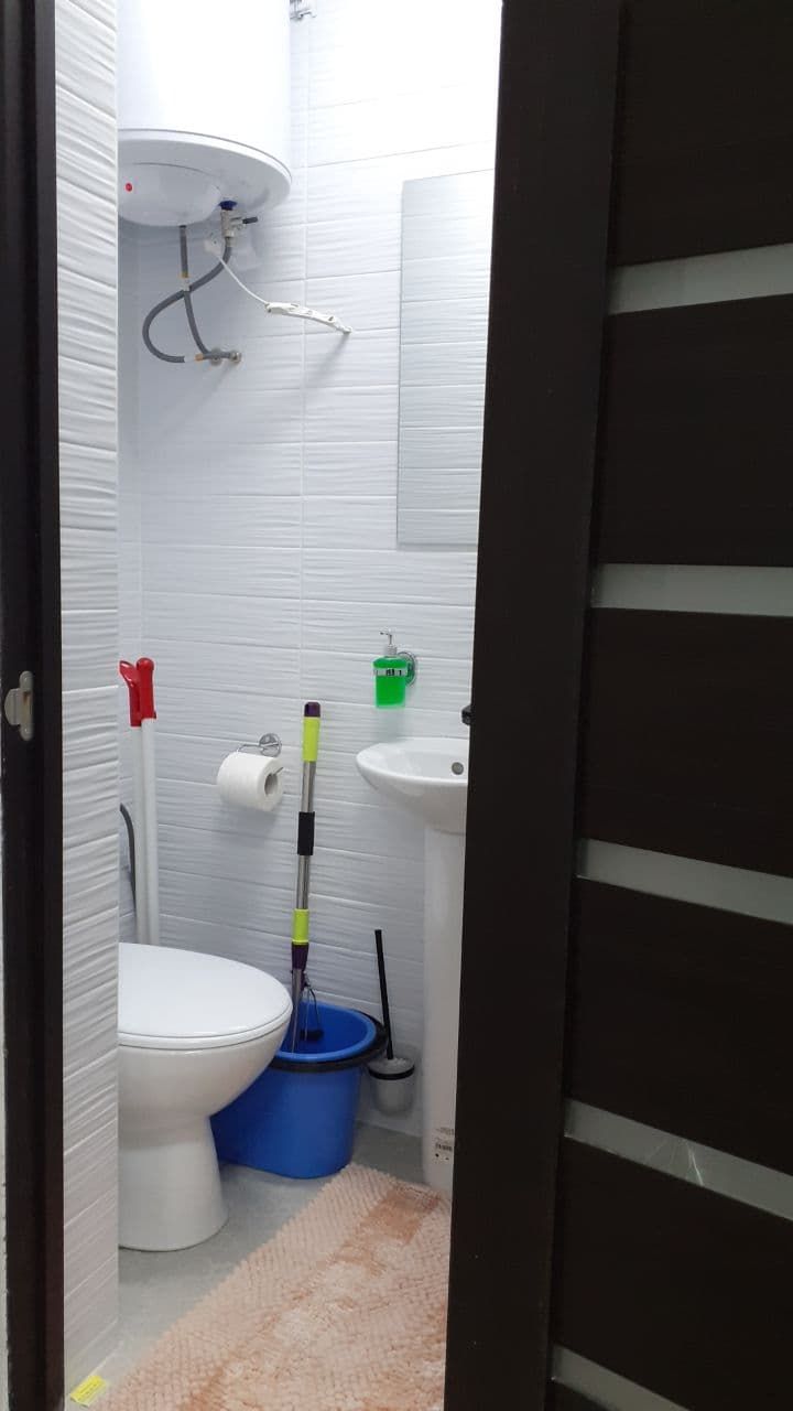 A small bathroom with a toilet, sink, and shower.