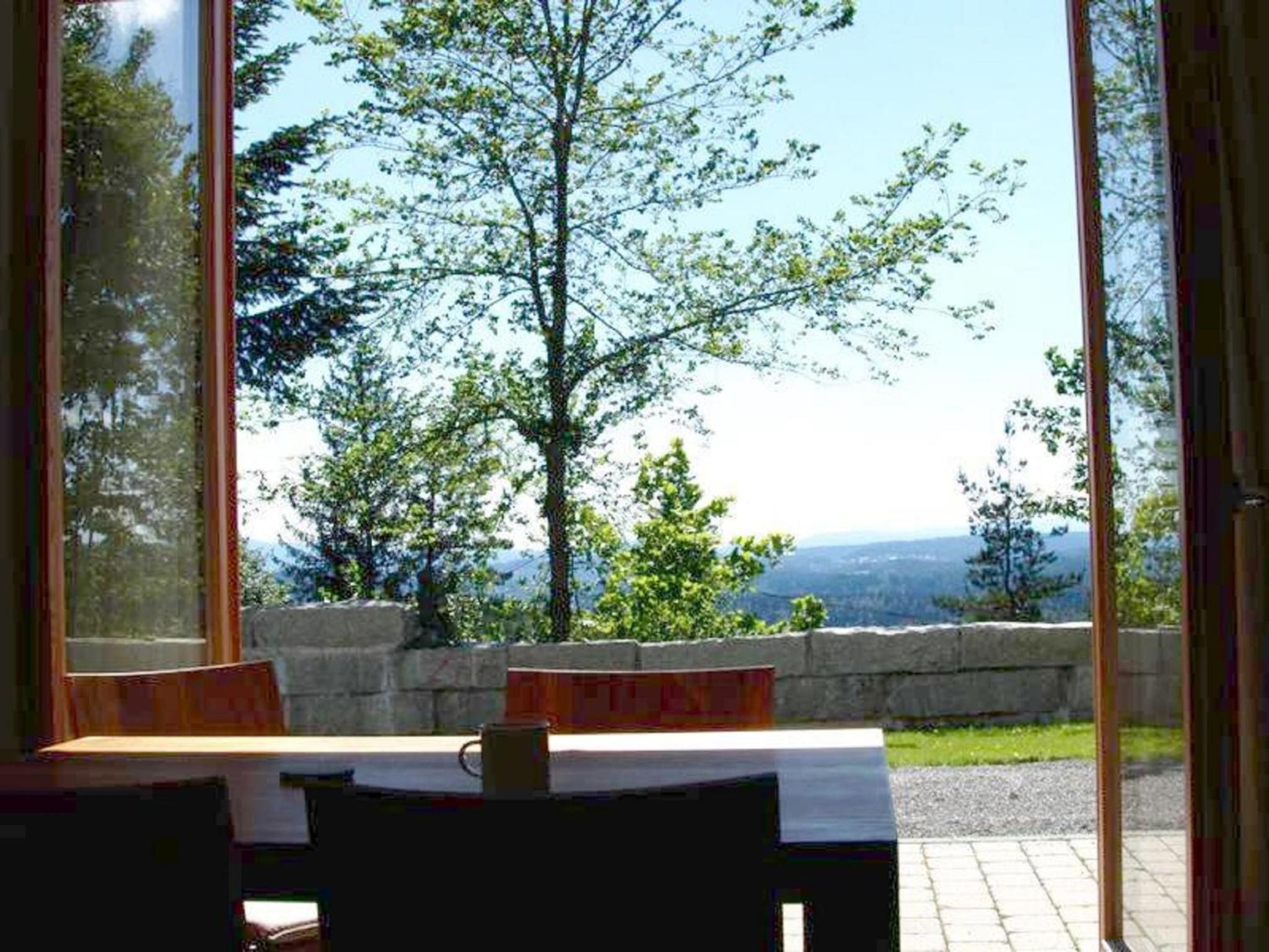 Ein Tisch mit Blick auf eine gebirgige Landschaft durch ein Fenster.