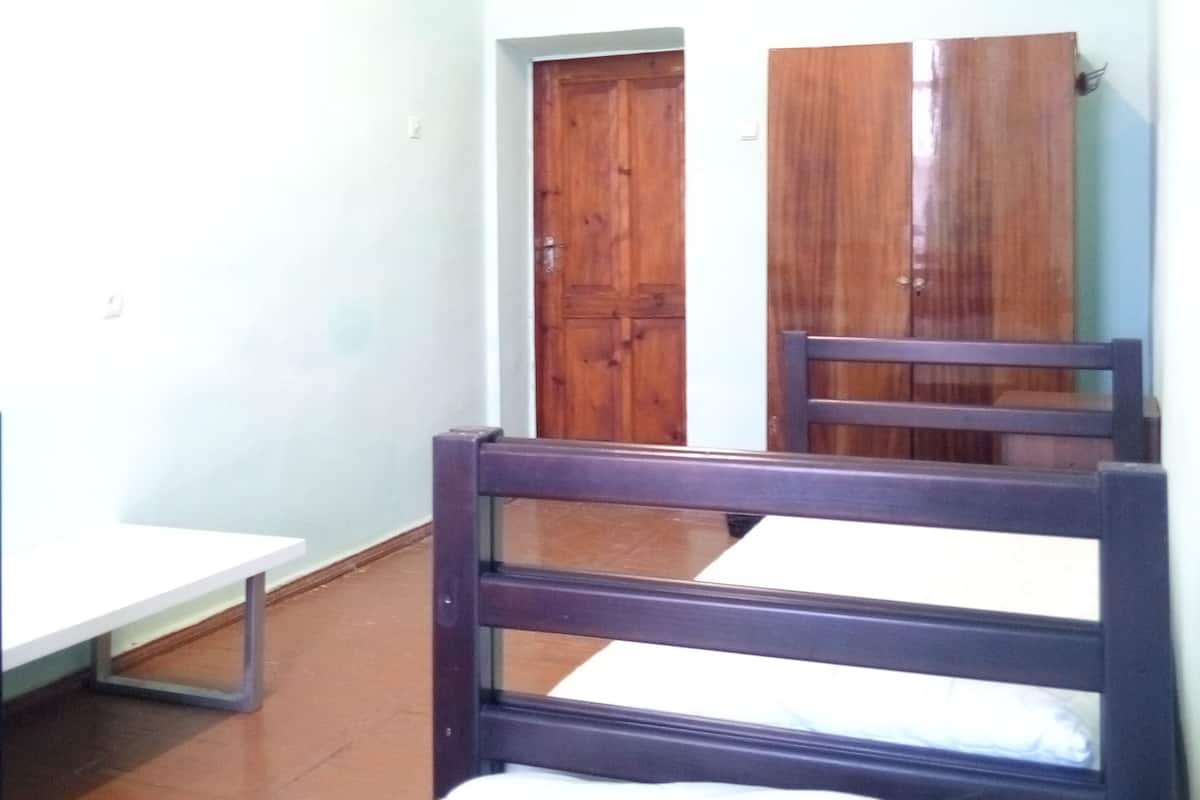 Una habitación con cama, escritorio y armario.