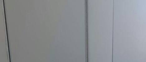 A hallway with two white doors, each with a round handle and a keyhole.