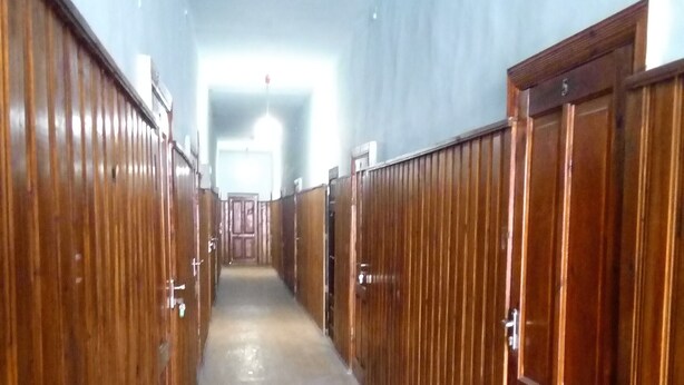 A long hallway with wooden lockers on both sides and a carpeted floor.