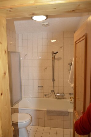 A bathroom with a toilet, a shower, and a bathtub. - Appartementhaus Osserblick (Lohberg)