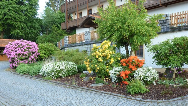 A building with a stone facade, wooden balconies, and a cobblestone pathway. - Appartementhaus Osserblick (Lohberg)
