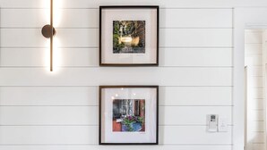 A room with a wooden floor, a patterned rug, a leather chair, and two framed pictures on the wall. - The Sunrise | 3BR Up - Best of Charleston Award! (Charleston)