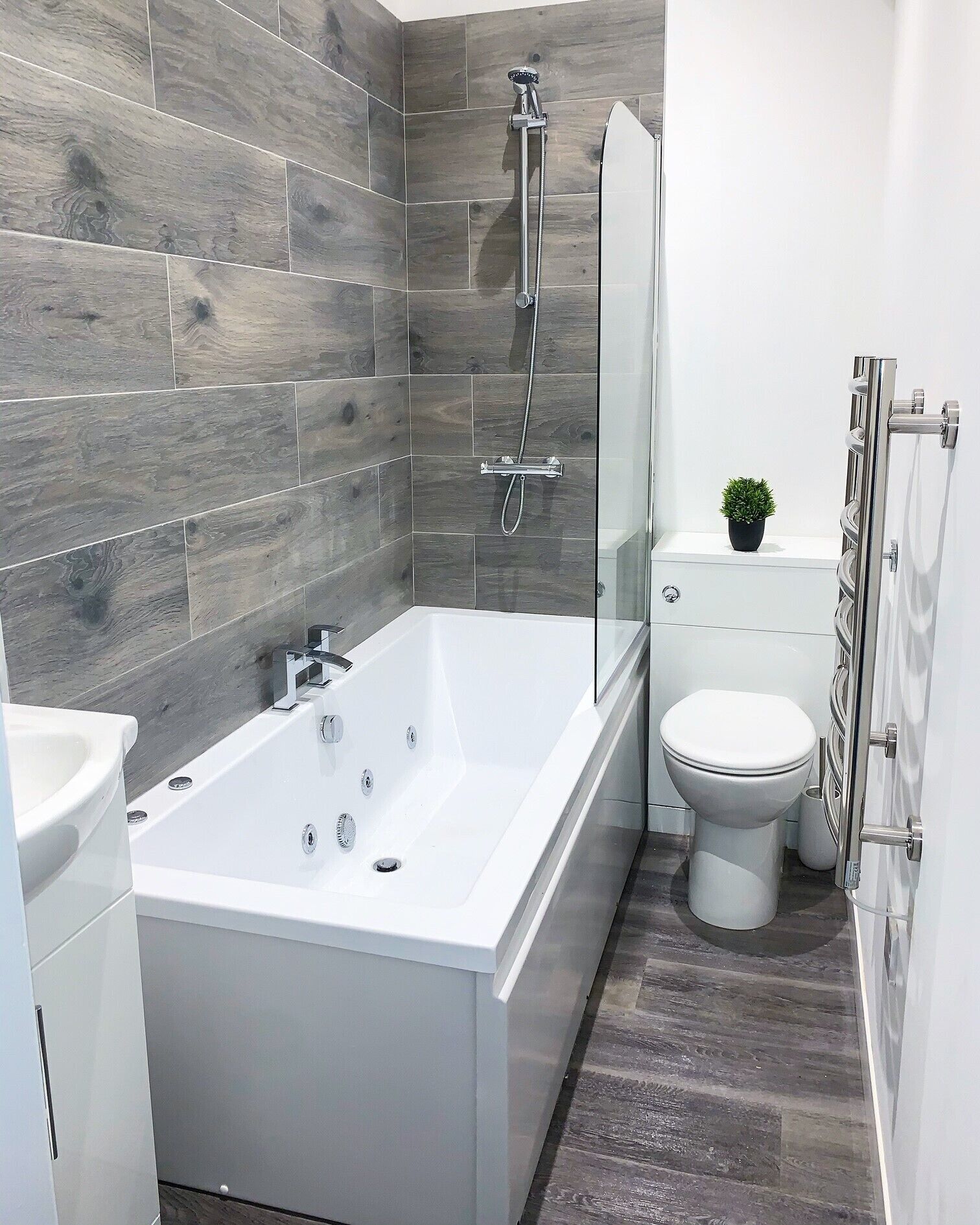 Et moderne badeværelse med et stort badekar, toilet og brusebad.