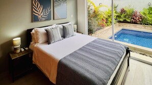 Una camera da letto con un letto, una ventola a soffitto, un condizionatore d'aria, un comodino e vista su una piscina.
