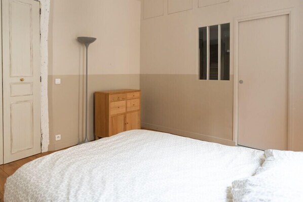 Une chambre à coucher avec un lit, une armoire et une porte.