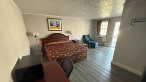 A room with a bed, a desk, a chair, and a window.