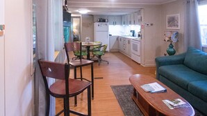 A compact living space with a dining area, a sofa, and a kitchen in the background. - Lakeside property. Private dock. Great for ANO! (Russellville)