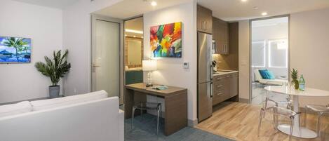 A modern apartment with a living room, a small kitchen, and a dining area.