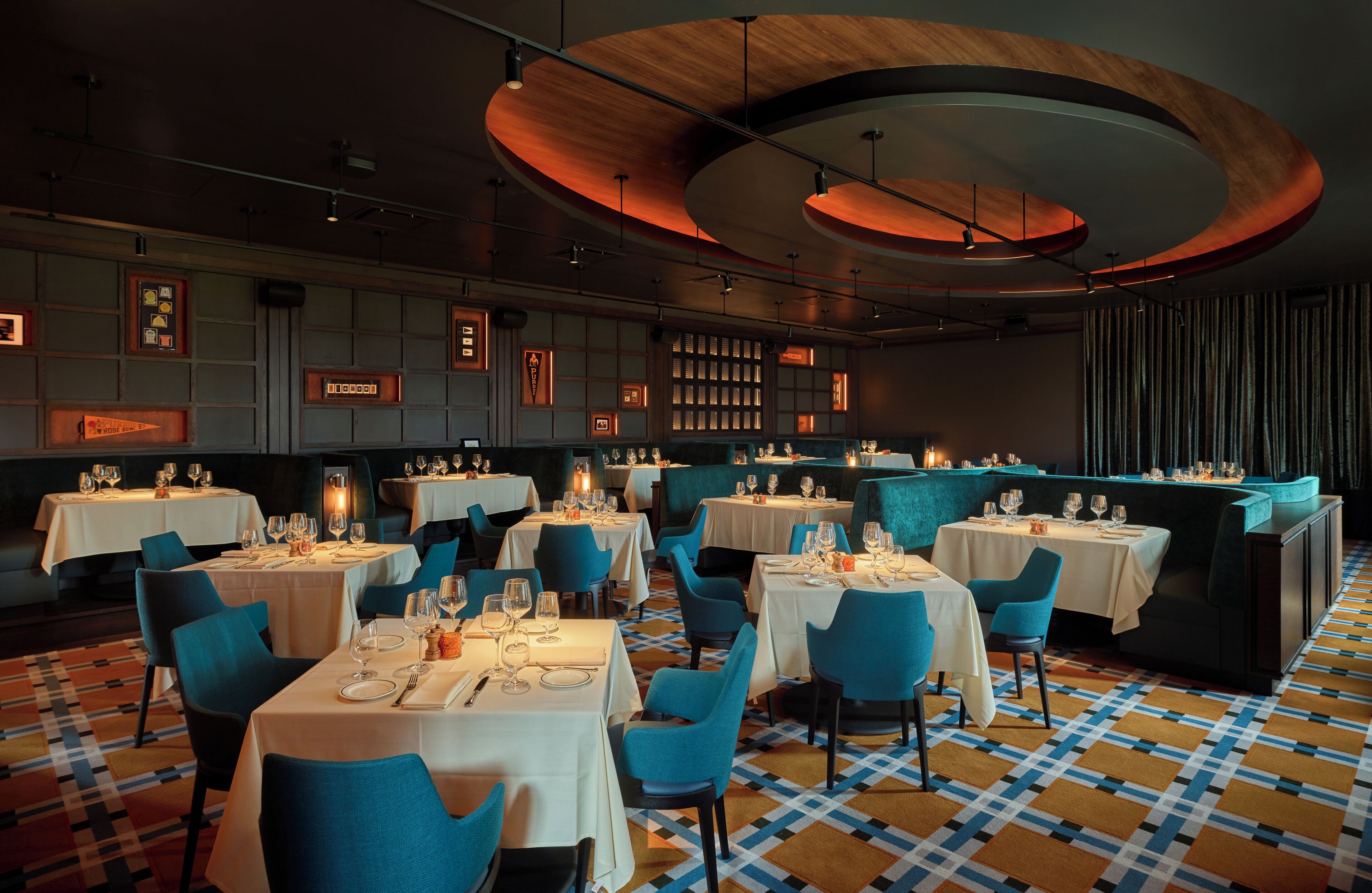 A restaurant with round tables, blue chairs, and a checkered floor.