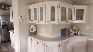 A kitchen with white cabinetry, a stainless steel refrigerator, a water dispenser, and a decorative vase. - Newly renovated, large deck, backs onto large pond (Sarasota)