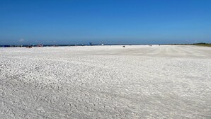 A wide, open sandy beach with a clear blue sky. - Newly renovated, large deck, backs onto large pond (Sarasota)