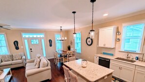 A spacious living area with a dining table, a kitchen with a granite countertop, and a small island. - 4 BR/ 4 BA/ Single Family - 2 Primary Suites (Ocean City)