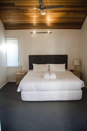 A bedroom with a large bed, wooden ceiling, and two bedside lamps. - House 15 - Dunsborough Beachside (Dunsborough)