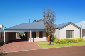 A single-story house with a covered driveway and a small tree in the front yard. - House 21 - The Classic Dunsborough (Dunsborough)