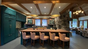 A spacious kitchen with a large island, bar stools, and wooden beams. - Mauna Hale - Ski-in, Ski-out Mountainside at Northstar Lake Tahoe (Truckee)