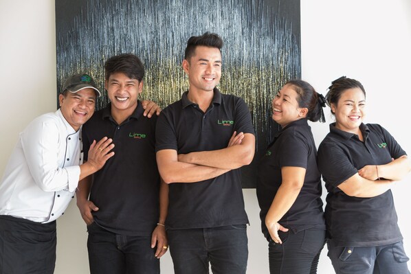 A group of people in black polo shirts with a logo, standing in front of a textured wall. - Villa Spice at Lime Samui (Koh Samui)