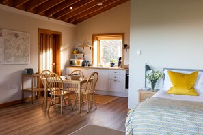 Enjoy a cozy stay in this compact room featuring a dining table, kitchenette with microwave and kettle, and a comfortable bed.