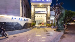 The exterior of the Salah Hotel with a clear entrance, potted plants, and a bicycle parked outside. - Salah Hotel Quy Nhon (Quy Nhon Nam)