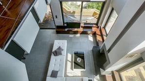 A modern living area with a white sofa, a small coffee table, and a hammock. - Villa Opuntia (Chania)