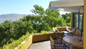 A terrace with a view of the landscape, a table, chairs, and a hammock. - Villa Opuntia (Chania)