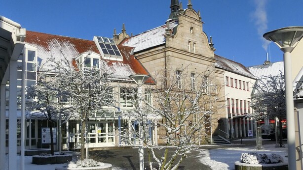 A historic building with a prominent tower and a modern structure with large windows. - Ferienwohnung Singer (Schnaittach)